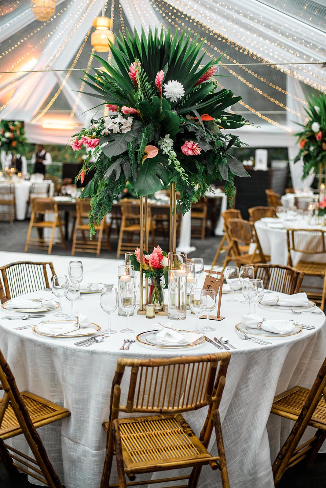 Bohemian wedding decor. There are large monstera leaves and anthuriums statements pieces for each table.
