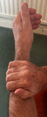 Squeezing thumb muscles of forearm while moving thumb.