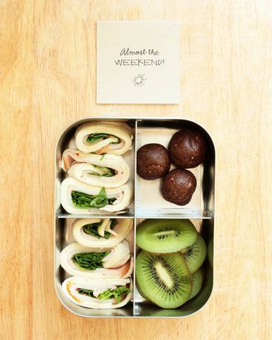 metal lunchbox with turkey wrap kiwi and energy balls