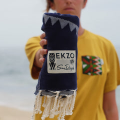 Women in yellow shirt holding blue towel with tassels in her hand