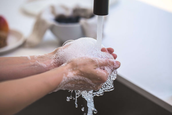 Hands with foam that is created by adding surfactants such as SLS and other harmful ingredients to soap