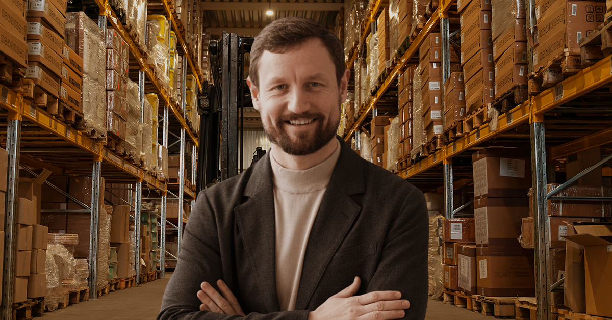 Business man in his logistic warehouse with boxes of products