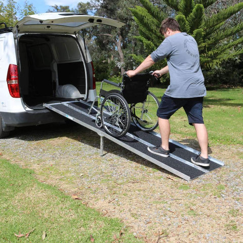 Heeve Aluminium Multi-Fold Super-Grip Wheelchair Ramp on a van with a man pushing a wheelchair