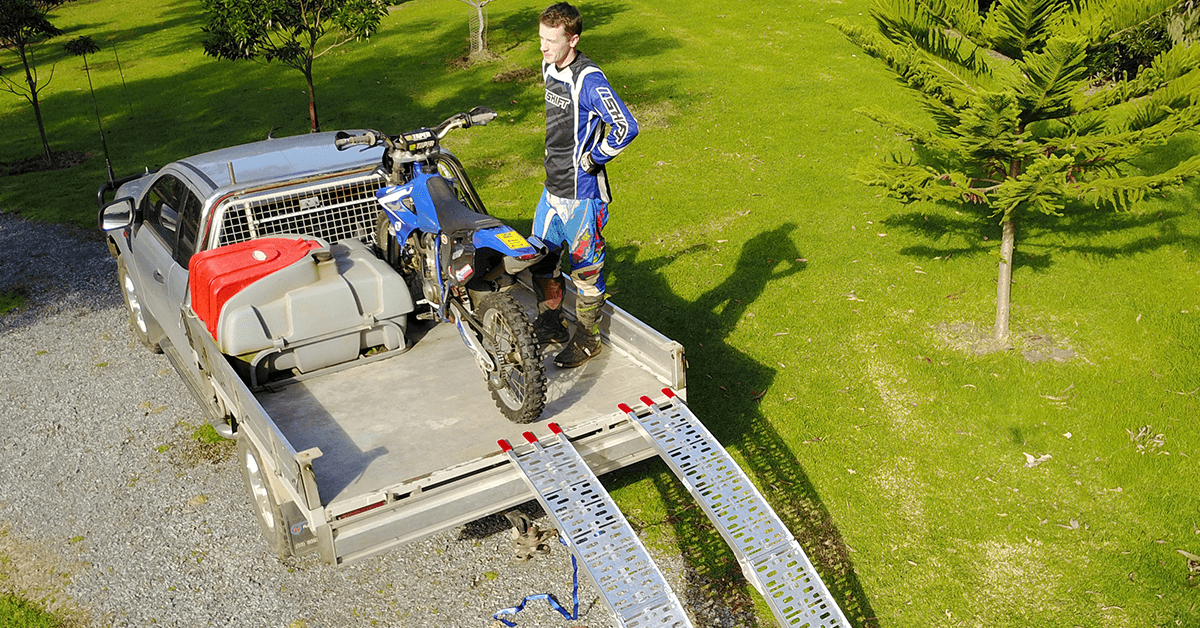 A man succesfully loaded the motorcycle to his truck using the ramps