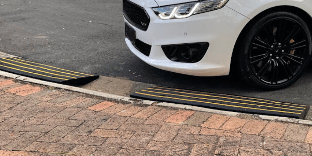 white bump car parked along the driveway with rubber kerb ramp with black and yellow linings