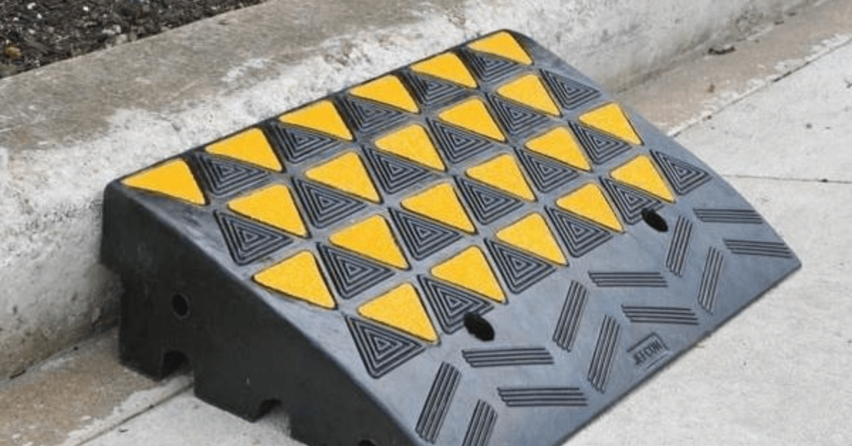 Image of a black and yellow rubber kerb ramp installed on a square type kerb