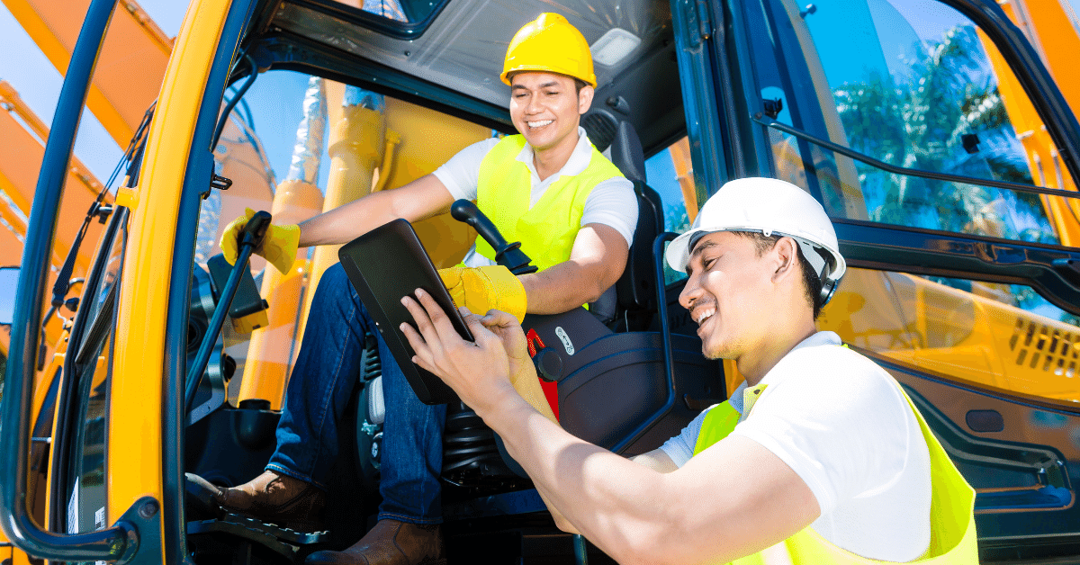 Man riding a construction machinery and another man showing the machine information 