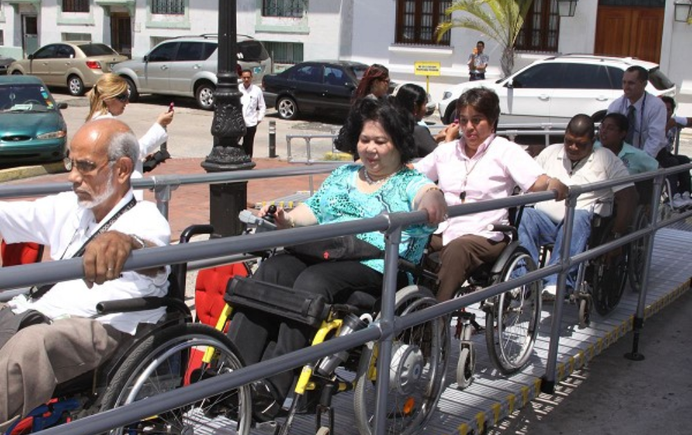 Group of people on a wheelchair using roll-a-ramp