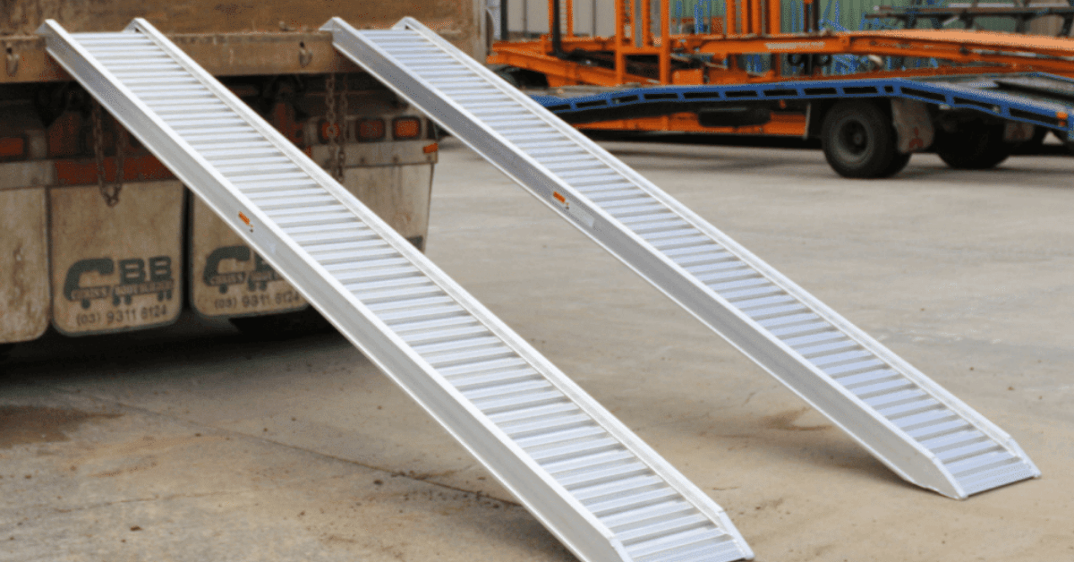 Pair of aluminium loading ramps attached to a truck