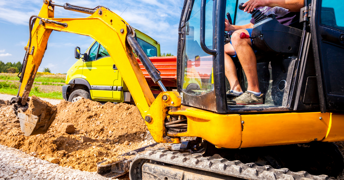 An image of a mini excavator operated by a man
