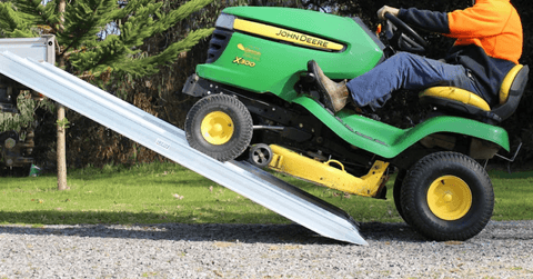 Image of a lawnmower loading a ute on a pair of Heeve loading ramp