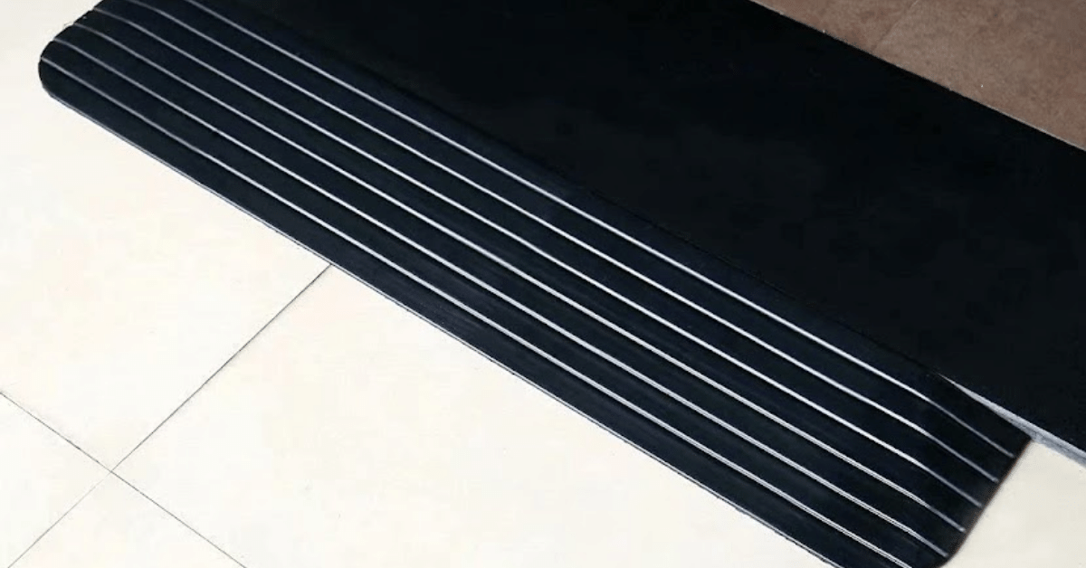 A black rubber threshold ramp installed on a front door