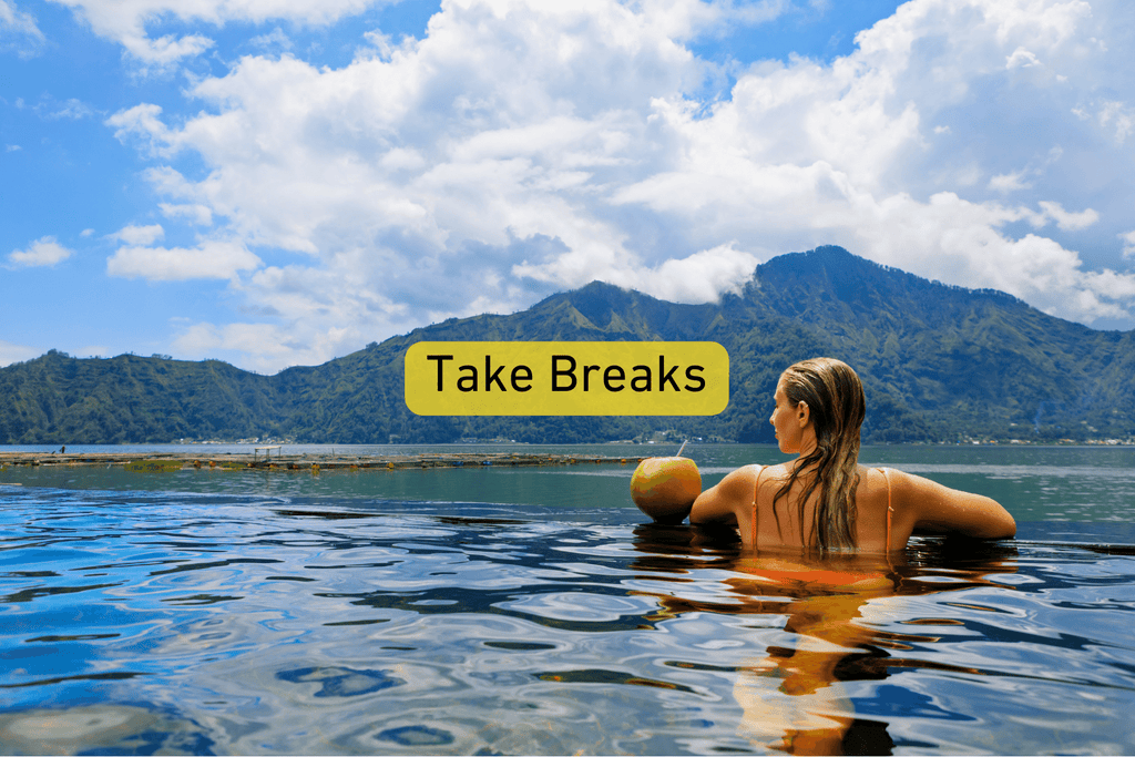 photo of a woman in an infinity pool at a tropical location with Take Breaks text overlay