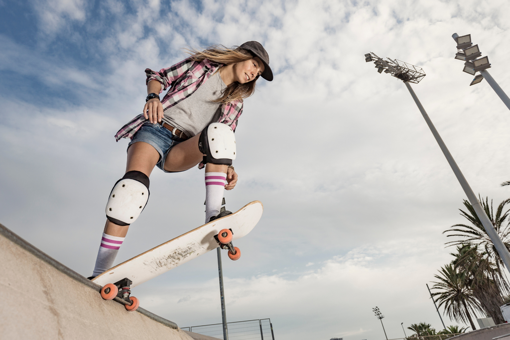 woman wearing protective gear while skateboarding