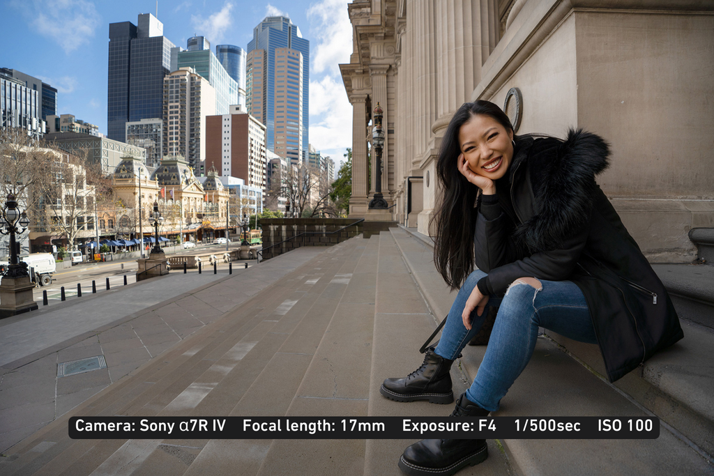 young lady sitting outside on the steps of a historic building