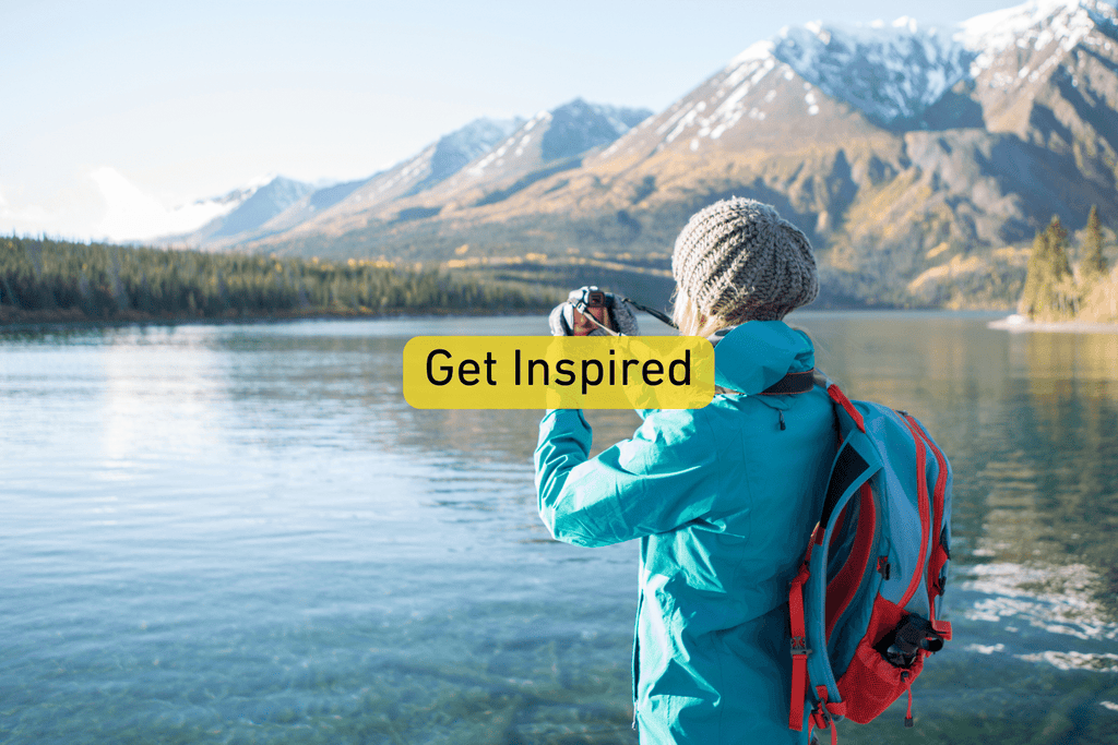 hiking photographer taking photos of scening lake and mountain landscape with Get Inspired text overlay