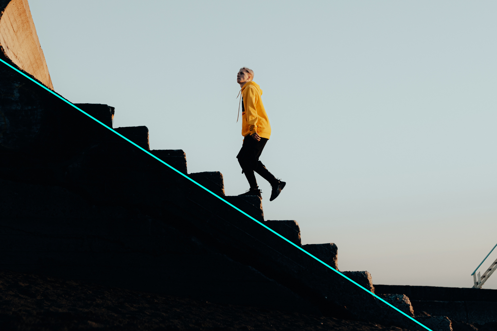 person wearing a bright orange west running up the stairs, horizontal leading lines overlay