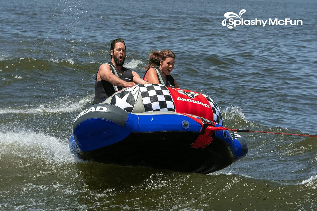 This is the Airhead Chariot 1-2 Rider Warbird 2 on the water with 2 people on it being dragged by a speedboat.