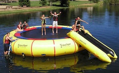 Island Hopper Giant Jump 25ft Water Trampoline green and tan. 6 kids play on the yellow and round water trampoline.