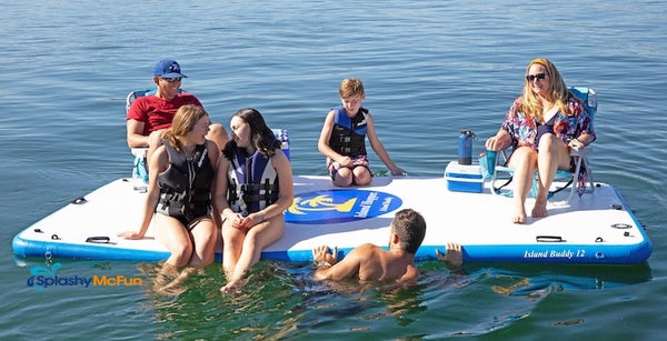 A family sits on a 12ft Island Hopper Island Buddy. They have cooler and folding chairs. Others sit directly on the inflatable dock