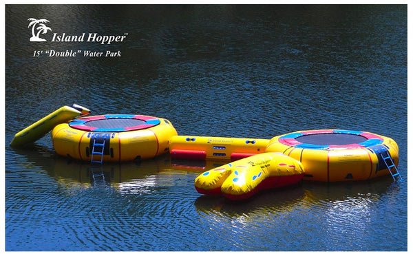 2 water trampolines sit on a lake connected with an island runner.