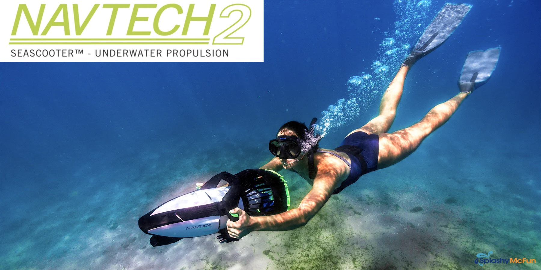 A young woman dives with her Nautica Navtech 2 Sea Scooter in clear blue water