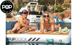 Pop Board Co PopUp Inflatable Dock. Image shows a guy and girl enjoying a day on the water in the sun on their PopUp Inflatable Dock. Boats are in the background