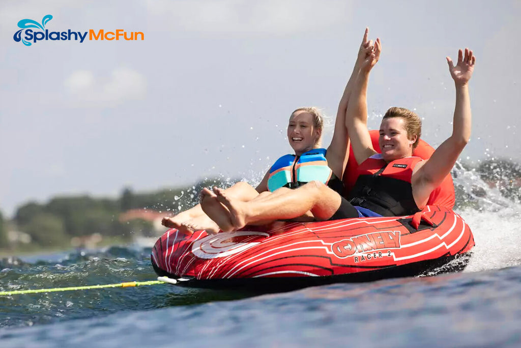 This is the Connelly Racer 2 with 2 people sitting on it in holding hands while one of them is holding onto the handles while being dragged by a speedboat on the water.