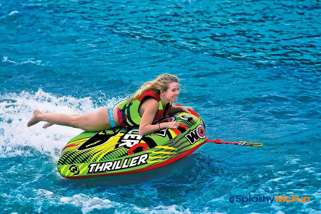 This is a Deck Tube in action on water with a person laying chest-flat on it holding onto the handles while getting pulled around on the water.