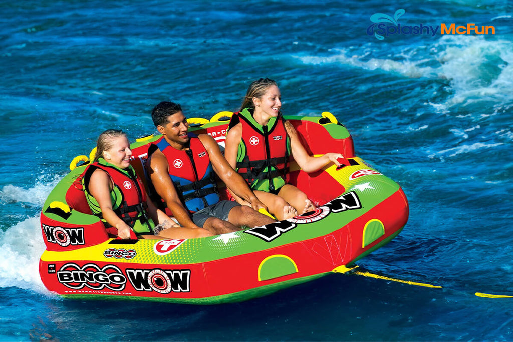 This is a Ride-in Tube with 3 people sitting on it while being dragged by a speedboat on the water.
