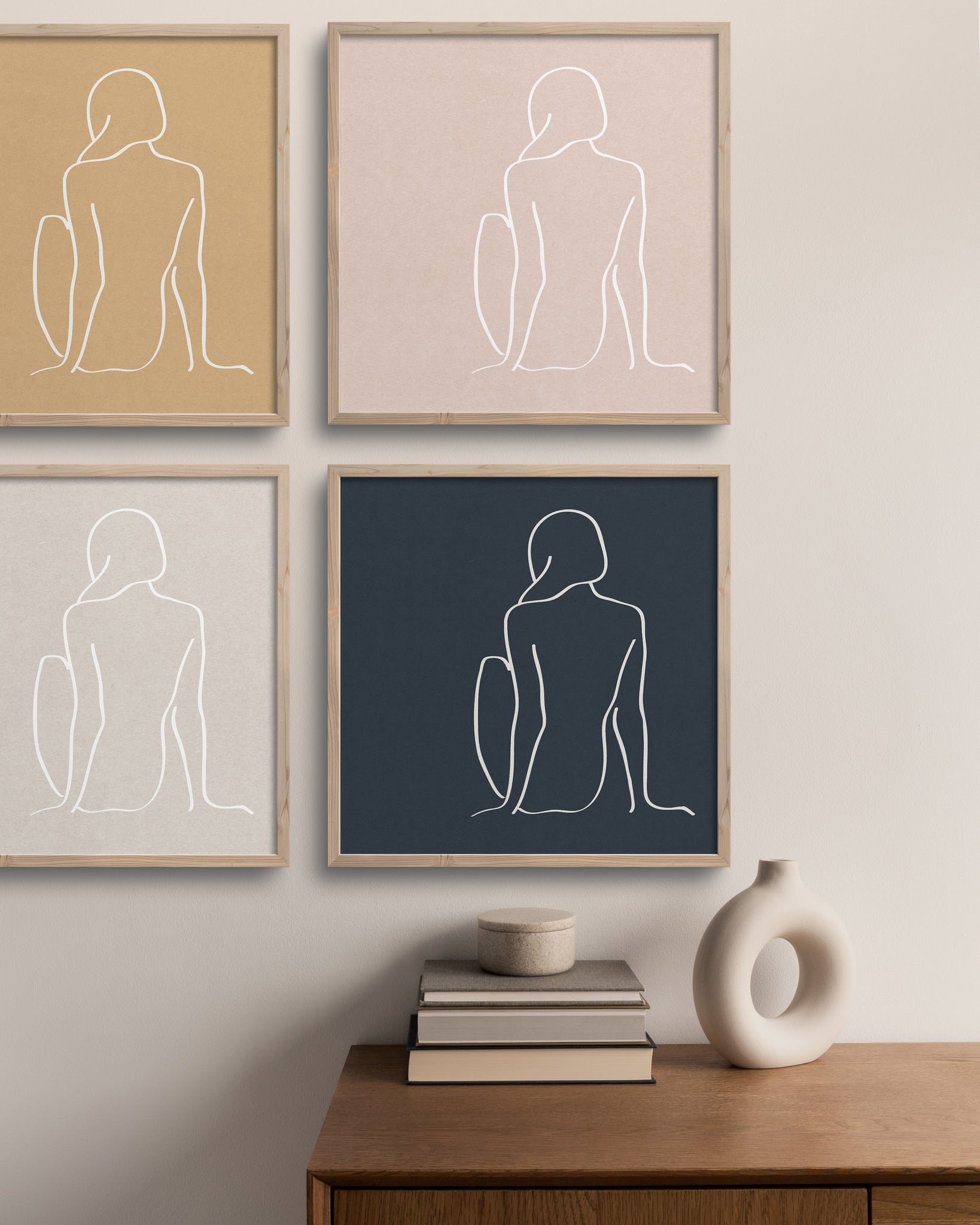 4 prints of a girl sitting. cream wall with table below