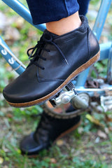 A Chukka boot being shown off on a bicycle pedal.