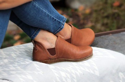 A person's legs crossed while sitting showing off the comfy and stylish Lieben Chelsea Boot in Vegetable Tanned Leather from Stegmann.