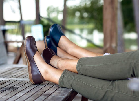 Two people sitting with their feet up wearing very comfy, yet dressy Stegmann Leather Liesl Skimmer in Brown dress shoes.