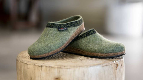The comfy, stylish and supportive Original 108 Clog - Sage colorway sitting on top of a log.