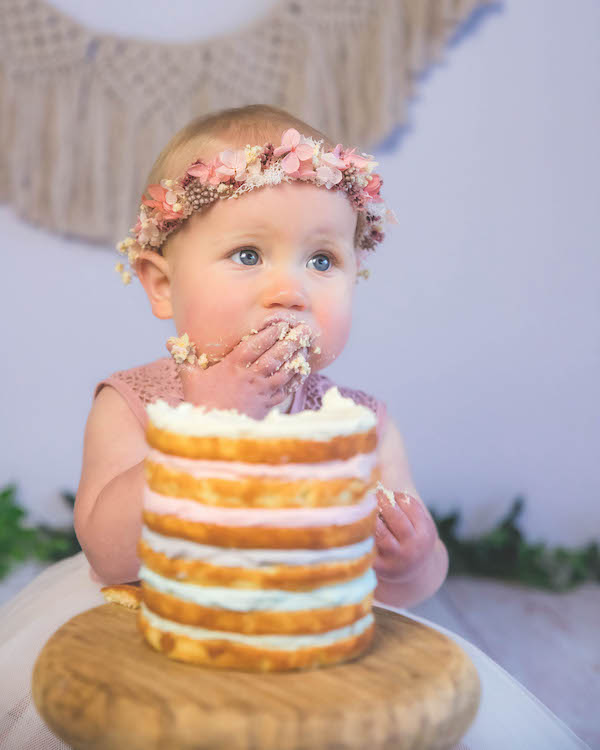 Baby shovelling cake in to her mouth during DIY cake smash photoshoot