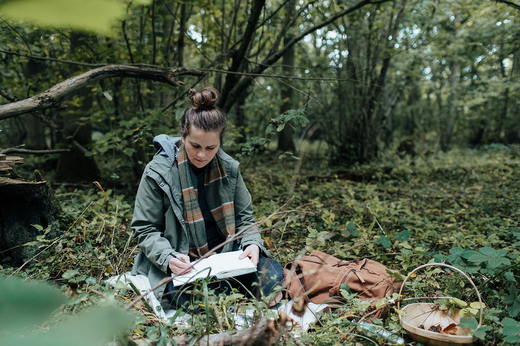 Agnes sits in the woods sketching