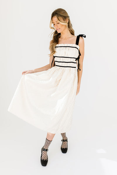 white midi dress with black ties for a homecoming dress idea