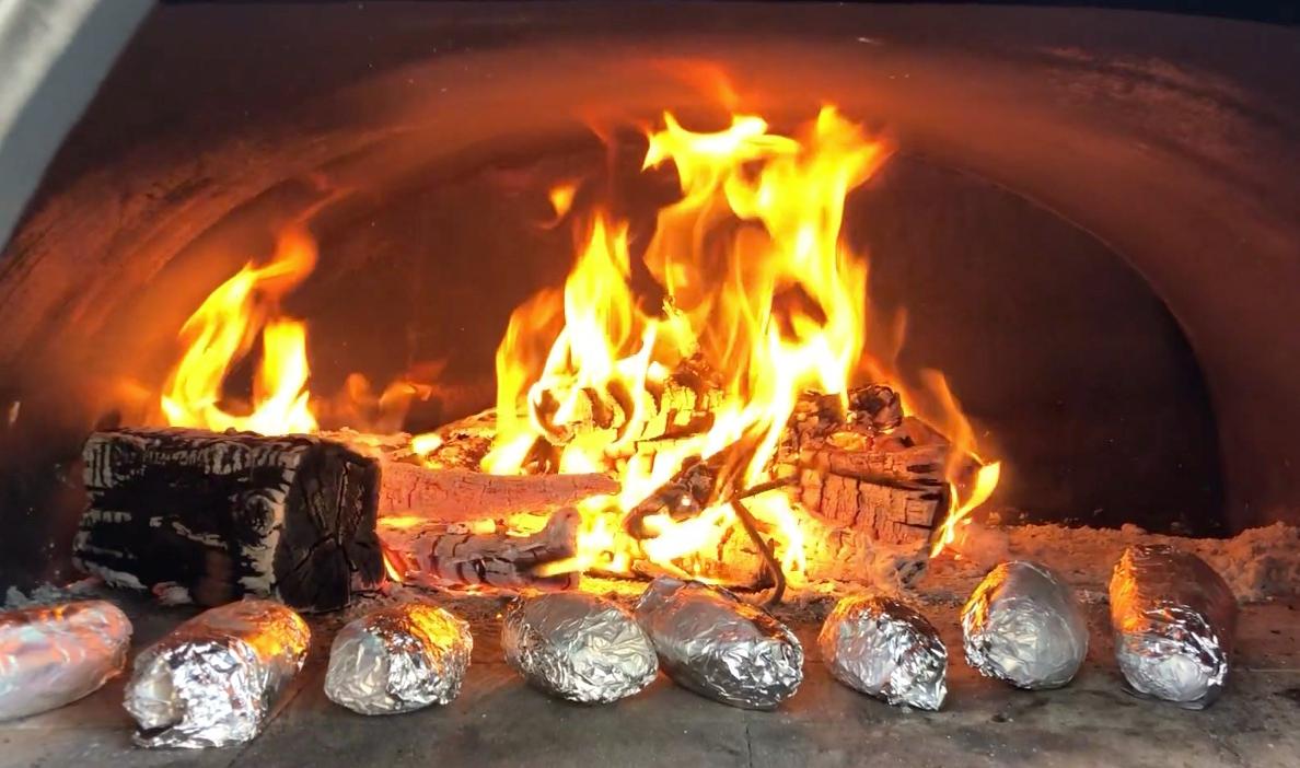 Potatoes baking in a wood-fired pizza oven