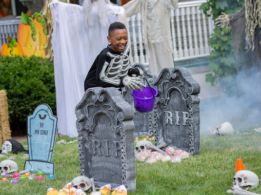 Boy on a Halloween scavenger hunt in a pretend cemetary