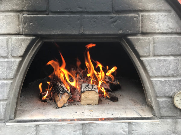 Pizza oven with cooking wood on fire