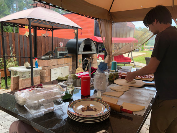 Rolling dough to make pizza in the wood fired pizza oven