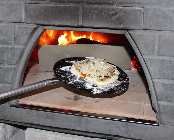 Pizza going into wood fired oven