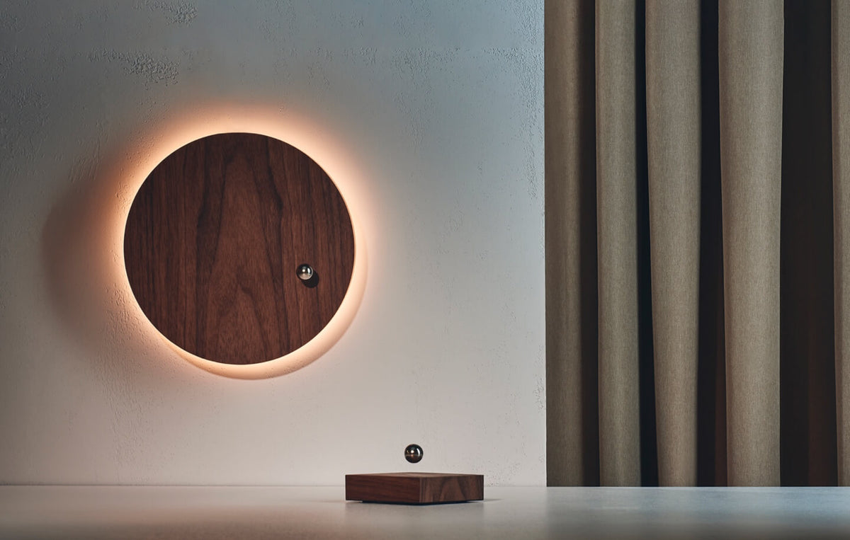 Refurbished levitating timepiece and levitating sphere on a light background