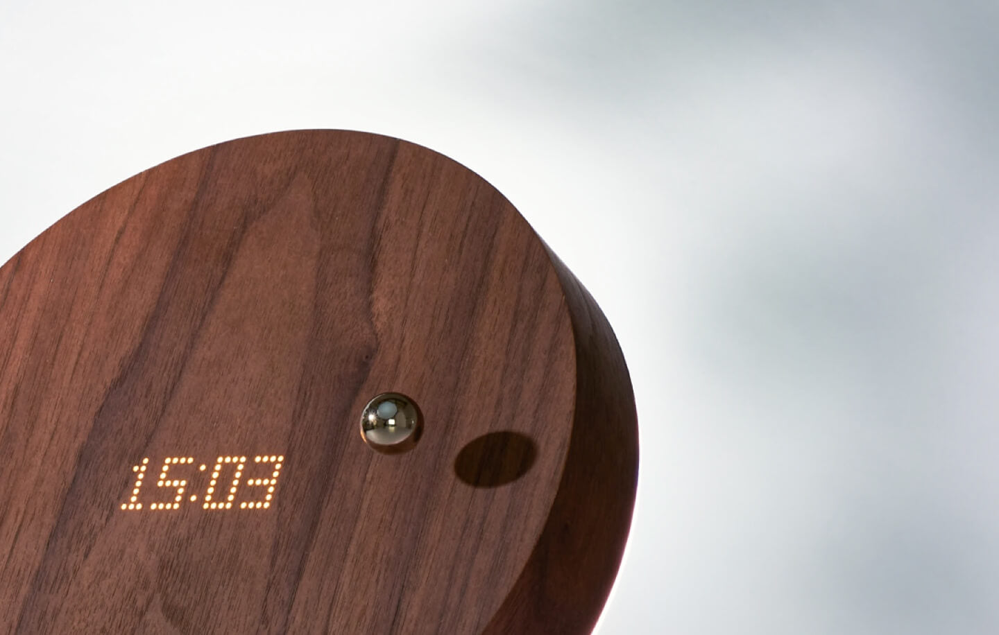 Close up of a Story levitating wooden timepiece walnut cover version on a light background