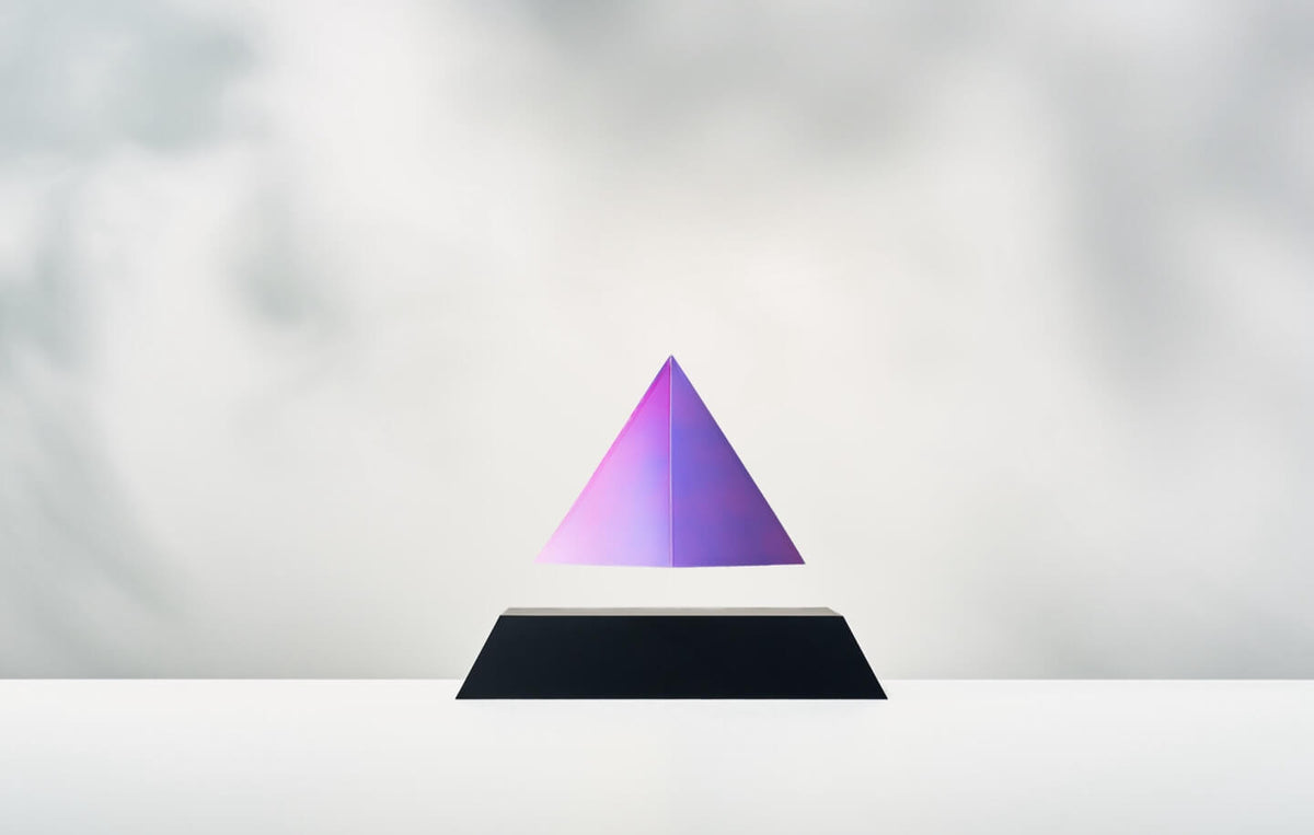 Py levitating pyramid, black base, iridescent top on a light background