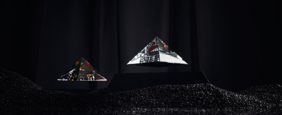 Levitating Pyramid Py by Flyte, clear and iridescent version in a dark interior setting