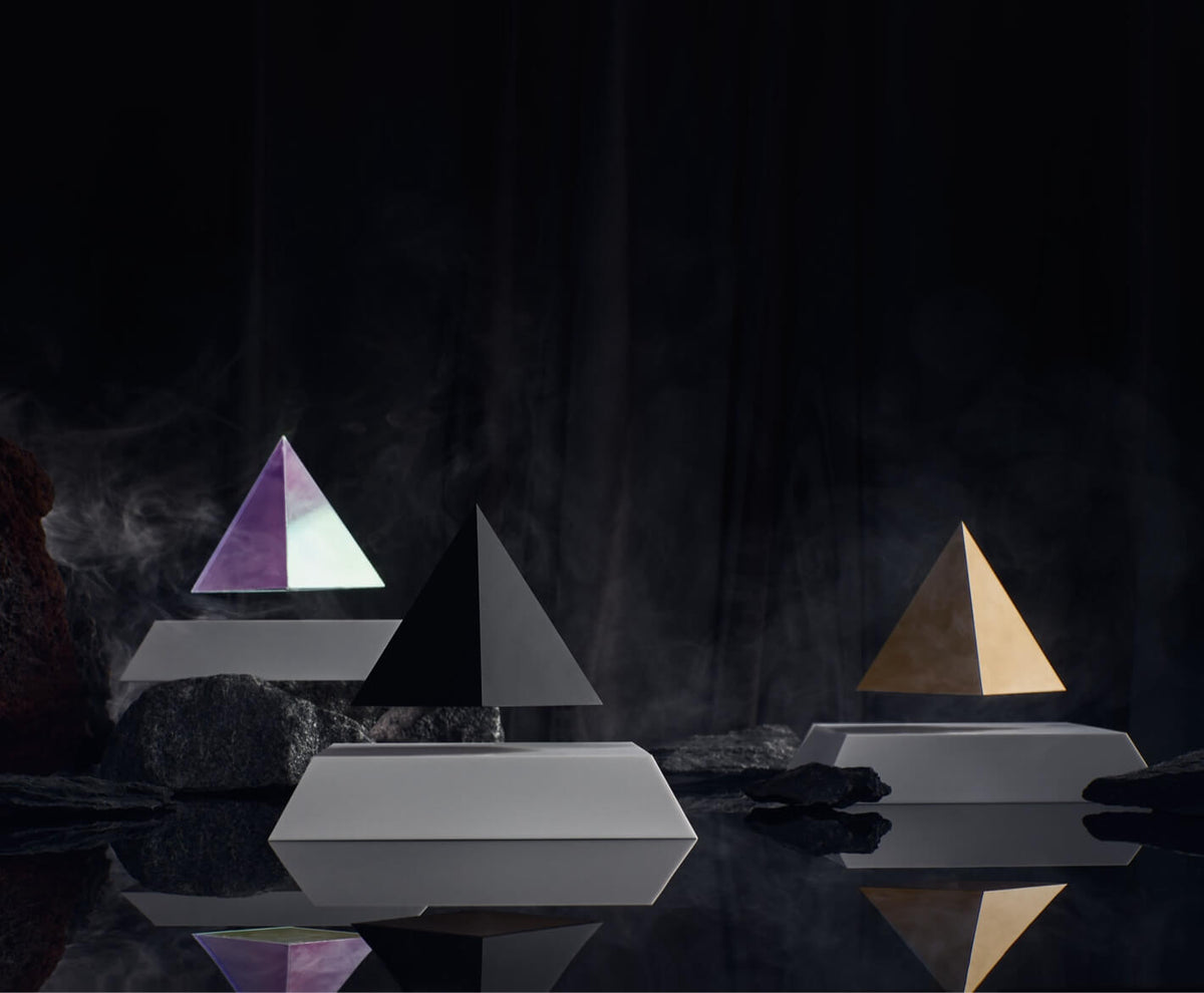 Different kinds of Py levitating pyramid surrounded with rocks in a dark setting