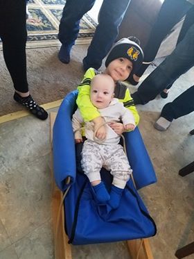 two children on wood sled