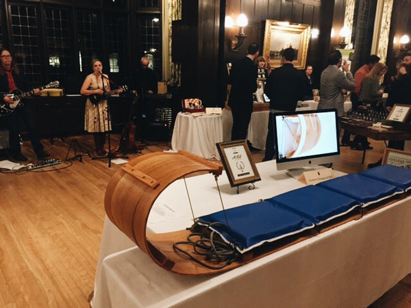 wooden sled on a table in front of a plaque and a small band